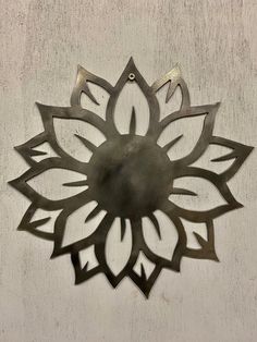 a metal flower on the side of a wall