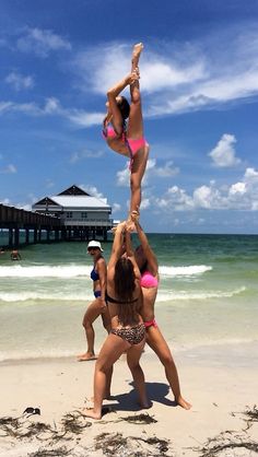 two women doing acrobatic tricks on the beach