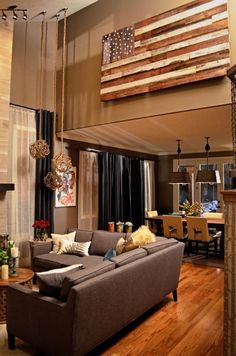 a living room filled with furniture and an american flag hanging from the wall above it