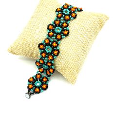 Fun Handmade Beaded Floral Bracelet With Black, Aqua, Orange And Yellow Seed Beads Woven Into A Connected Flower Pattern. Finished With A Black Metallic Magnetic Clasp For Easy On And Off. This Gorgeous Piece Is 7” Long With Flowers At About 1” In Diameter. Gifts Party Summer Spring Festival Colorful Feminine Hand Crafted Handcrafted By Me So Each Piece Is One Of A Kind. Your Order Is Beautifully Packaged With Care And Shipped The Same Or Next Business Day. Multicolor Beaded Flower Shaped Jewelry, Adjustable Flower-shaped Jewelry With Colorful Beads, Bohemian Flower-shaped Jewelry With Colorful Beads, Multicolor Flower-shaped Beaded Bracelets, Beaded Flower Bracelet, Black Flower-shaped Jewelry With Colorful Beads, Party Summer, Floral Bracelet, Spring Festival