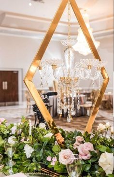 a table topped with flowers and candles next to a chandelier