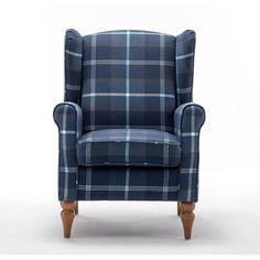 an upholstered blue plaid chair with wooden legs and foot rests against a white background