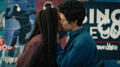 two people kissing each other in front of posters