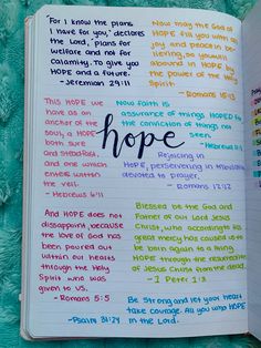 an open bible with the words hope written in rainbow colors on it, sitting on a blue blanket