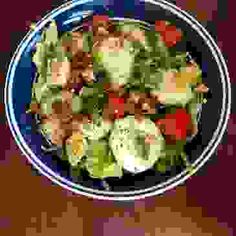 a plate full of salad with broccoli and cucumbers