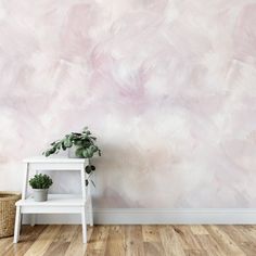 a white shelf with a potted plant on it in front of a pink painted wall