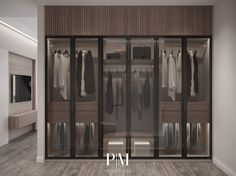 a walk in closet with glass doors and clothes hanging on hangers next to it