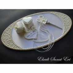 a white tray with pearls and wedding accessories on it, along with a pair of scissors