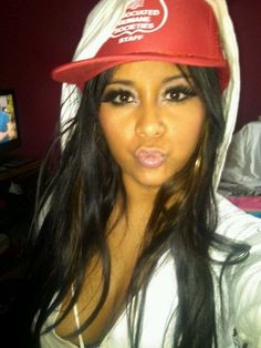 a woman with long hair wearing a red and white hat, posing for the camera