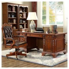 an executive desk with chair and lamp in the middle of a living room, next to a bookcase