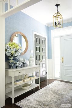 a hallway with blue walls and white furniture