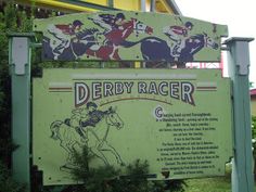 a sign for derby racer in front of a building