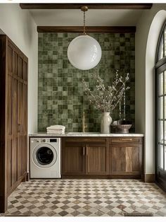 a washer and dryer in a room with green tiles on the wall, wood cabinets