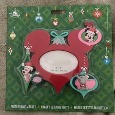 a mickey mouse christmas ornament in the shape of a heart with ornaments around it