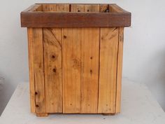 a wooden box sitting on top of a white table next to a vase and potted planter