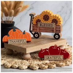 two wooden pumpkins sitting on top of a table next to a sign that says, thank