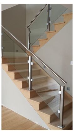 a stair case with glass balustrades and wood flooring in a house