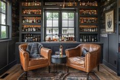 two leather chairs sitting next to each other in front of a bar filled with liquor bottles