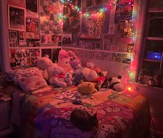 a bed with lots of stuffed animals on top of it in a room filled with posters and lights