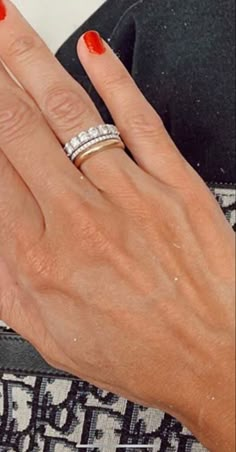 a woman's hand with two wedding rings on her left and one ring on her right