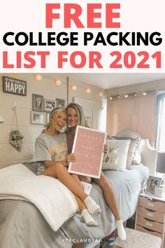 two women sitting on top of a bed holding up a sign that says happy birthday