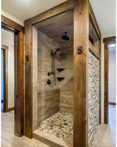 a walk in shower sitting inside of a bathroom next to a wooden door and window