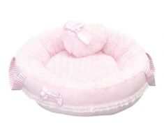 a pink dog bed with a bow on it