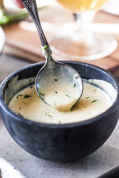 a close up of a bowl of dip with a spoon in it and the words dipm mustard dill sauce