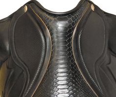 the back side of a black and gold leather motorcycle jacket with snakeskin pattern on it