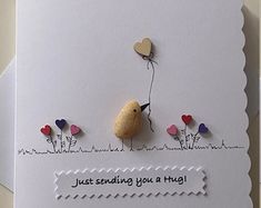 a greeting card with a bird holding a heart balloon on it's back and the words just sending you a hug