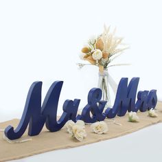 there is a blue sign that says mr and mrs on the table with flowers in it