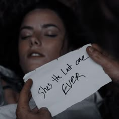 a woman holding a piece of paper with the words she's all one ever written on it