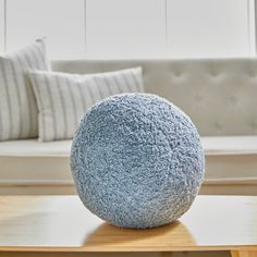 a blue ball sitting on top of a wooden table in front of a white couch