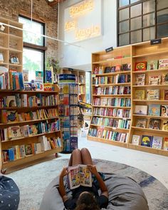 a person laying on a bean bag chair in front of a book store filled with books