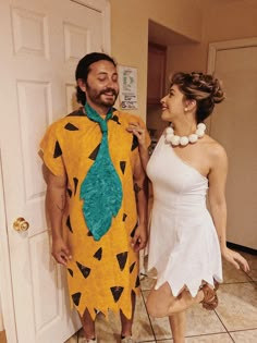 a man and woman in costumes standing next to each other on tile floored room