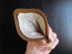 a hand is holding a small felt object