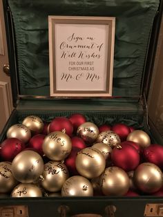 an open suitcase filled with christmas ornaments and a sign on the wall above it that says,