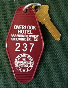 a red keychain with the words overlock hotel on it's side