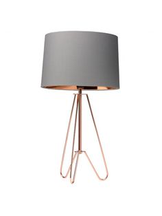 a table lamp with a grey shade on it and a metal stand underneath the lamp