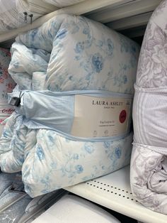 several pillows stacked on top of each other in a store display case, with the label labeled laurel & ashett