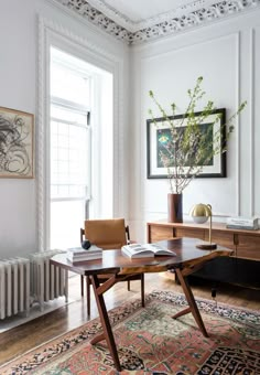 a desk with an open book on top of it in front of a radiator