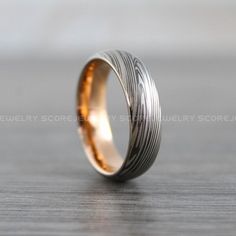 a wedding band with an engraved design on the inside is shown in gold and silver