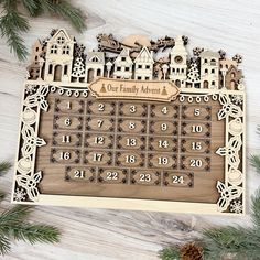 a wooden calendar sitting on top of a table next to pine cones and christmas decorations