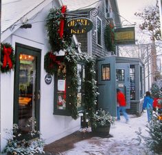 people are walking in front of a store decorated for christmas