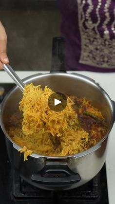 a person stirring food in a pot on the stove