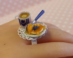 a miniature cupcake ring with blueberries and orange slices on it is being held by someone's hand