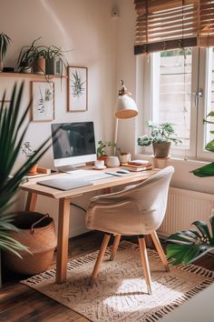 a desk with a laptop on it next to a potted plant in front of a window