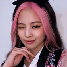 a woman with pink hair and black cat ears on her head is posing for the camera