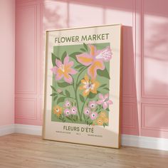 a flower market poster on the wall in a pink room with wood floor and pink walls