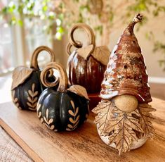 three decorative pumpkins sitting on top of a wooden table